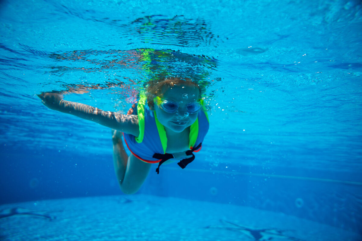 Enfant avec un gilet flottant dans une piscine